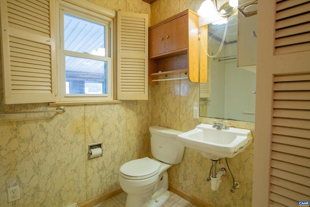 bathroom with toilet, sink, and tile flooring