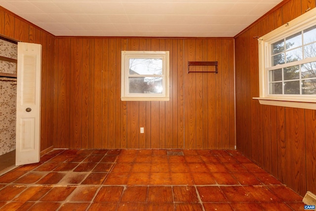 spare room with wood walls and dark tile flooring