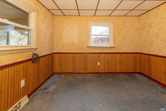 carpeted empty room with a paneled ceiling