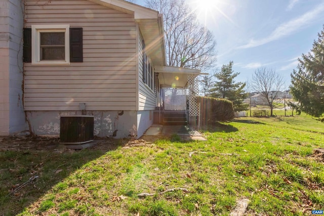 view of side of property featuring a lawn and central air condition unit