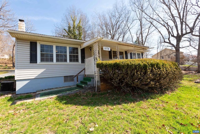 view of front of house with a front yard and central AC