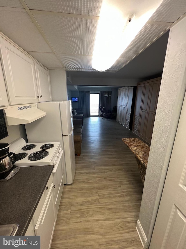 kitchen with white electric range, light hardwood / wood-style floors, and white cabinets