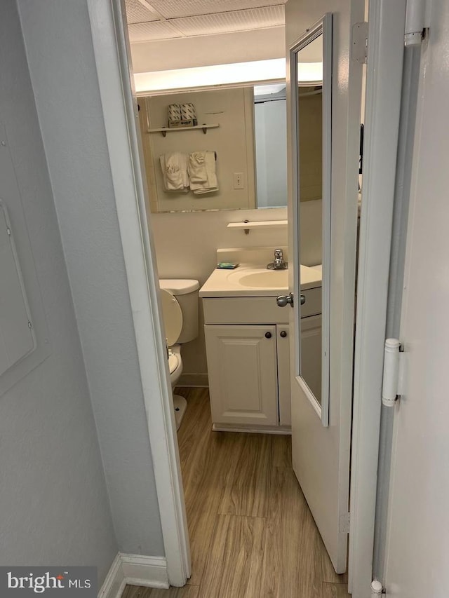 bathroom with hardwood / wood-style flooring, toilet, and vanity