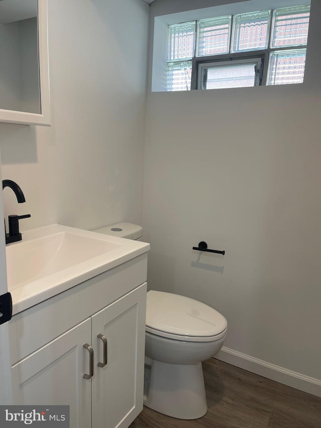 bathroom with oversized vanity, toilet, and hardwood / wood-style floors