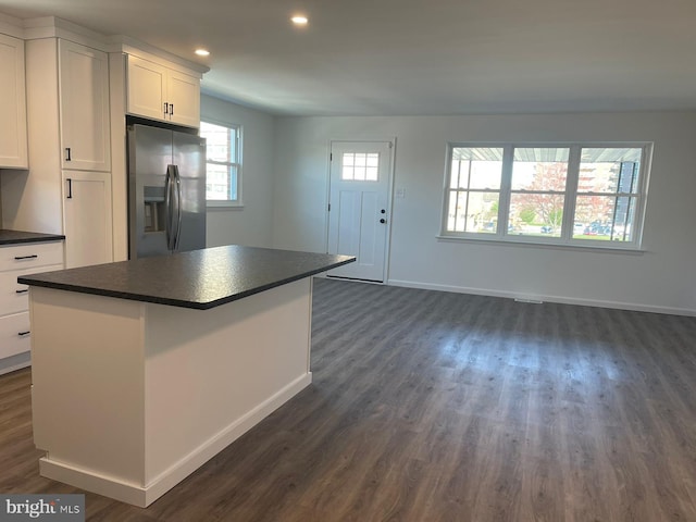 kitchen featuring a center island, white cabinetry, dark hardwood / wood-style floors, and stainless steel fridge