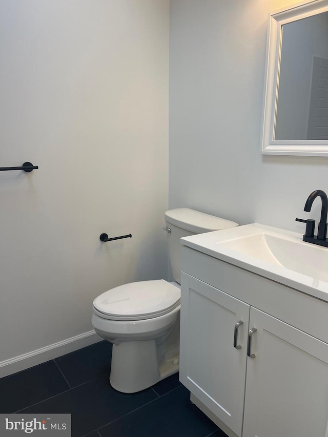 bathroom with vanity, tile floors, and toilet