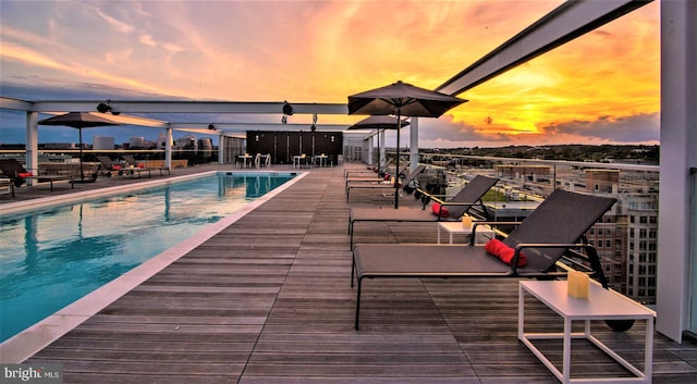 pool at dusk featuring a patio area