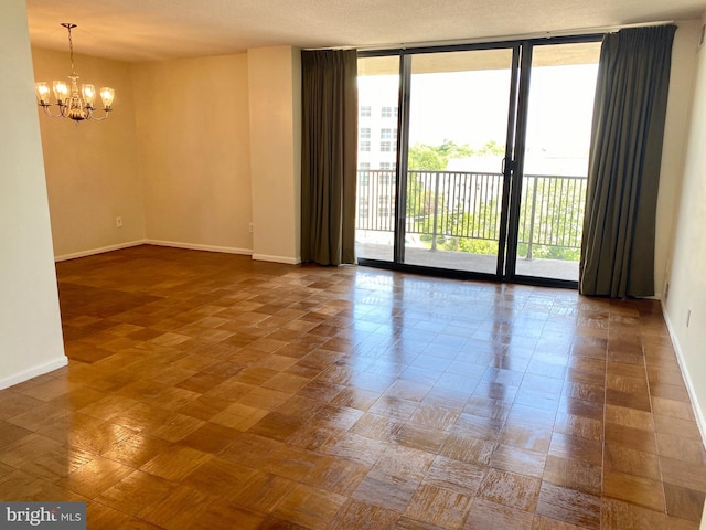 unfurnished room with expansive windows and an inviting chandelier