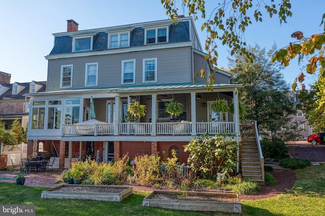 view of front of home featuring a sunroom, a patio area, and a front yard