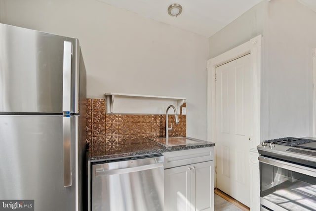 kitchen with sink, stainless steel appliances, light hardwood / wood-style floors, white cabinets, and decorative backsplash