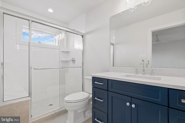 bathroom featuring vanity, tile patterned floors, ceiling fan, toilet, and a shower with shower door