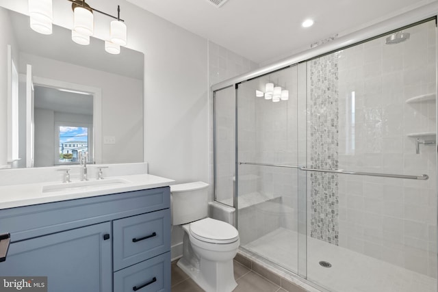 bathroom with tile patterned floors, vanity, toilet, and walk in shower