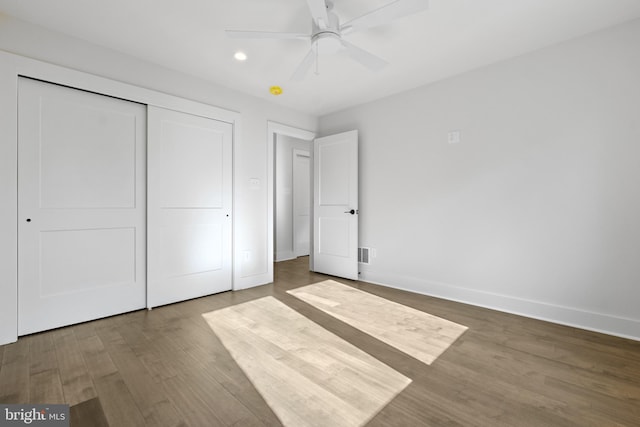 unfurnished bedroom with hardwood / wood-style floors, ceiling fan, and a closet