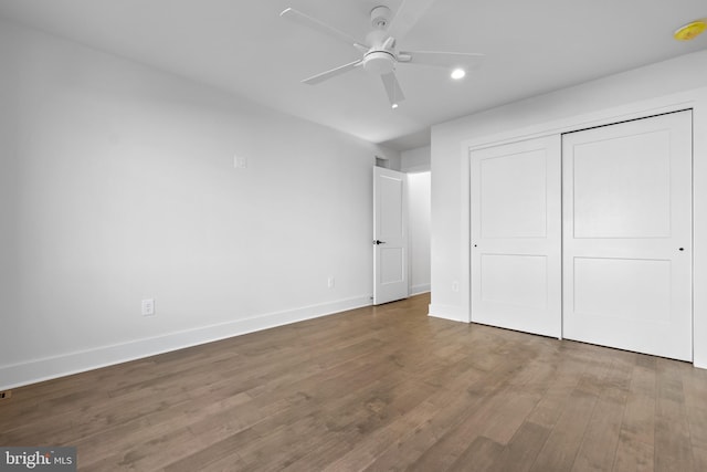 unfurnished bedroom with ceiling fan, a closet, and dark hardwood / wood-style floors