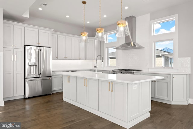 kitchen featuring island exhaust hood, stainless steel appliances, white cabinets, and a center island with sink