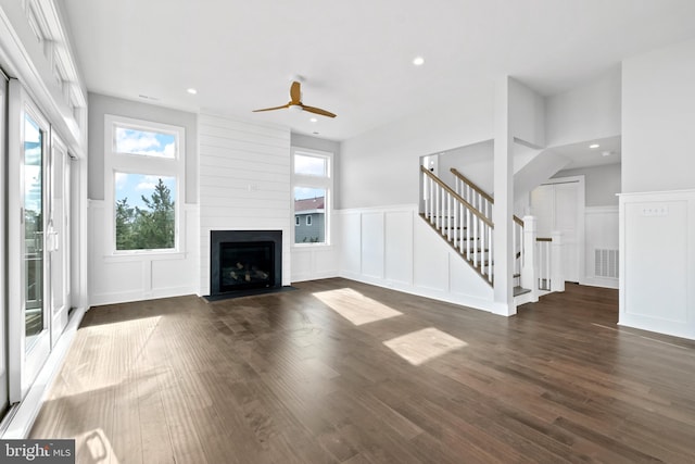 unfurnished living room with ceiling fan, a fireplace, and dark hardwood / wood-style floors