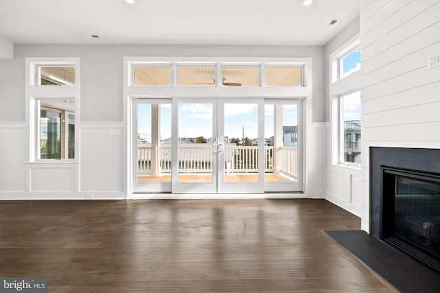 unfurnished living room with plenty of natural light and dark hardwood / wood-style floors