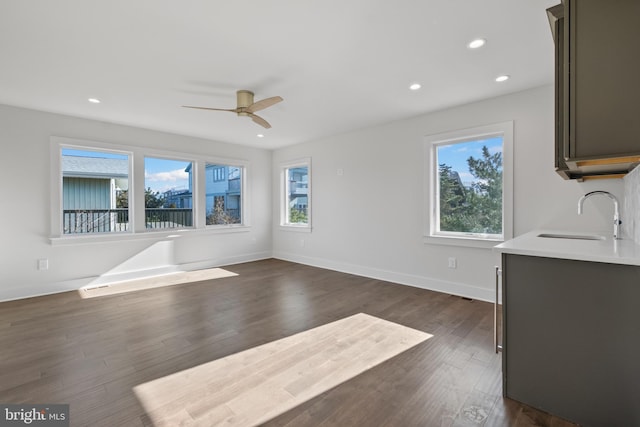 unfurnished living room with ceiling fan, dark hardwood / wood-style floors, and sink