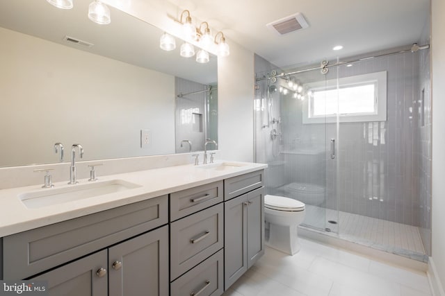 bathroom with tile patterned floors, vanity, toilet, and a shower with shower door