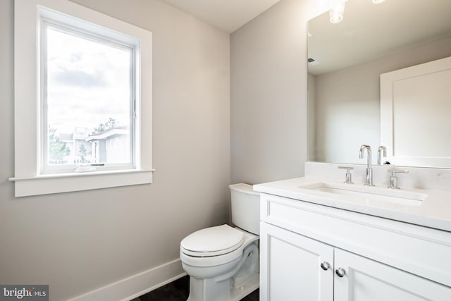 bathroom with a wealth of natural light, vanity, and toilet