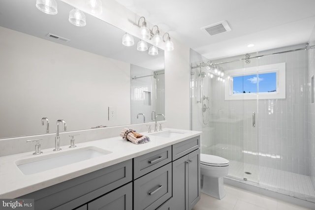 bathroom with tile patterned flooring, vanity, toilet, and a shower with door