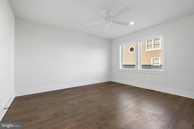 spare room with ceiling fan and dark hardwood / wood-style flooring