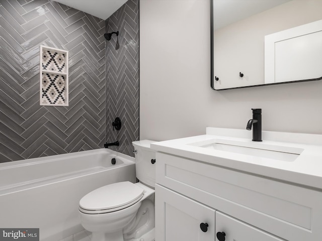 full bathroom featuring tiled shower / bath, vanity, and toilet