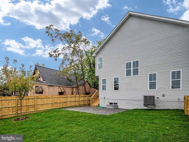 back of house with a lawn, a patio area, and central AC