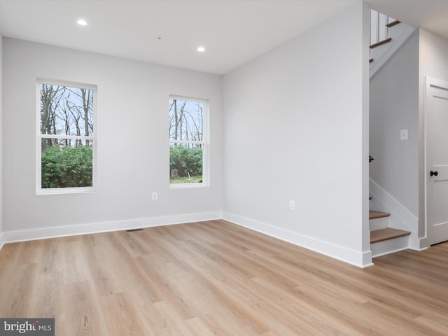 unfurnished room with plenty of natural light and light hardwood / wood-style floors