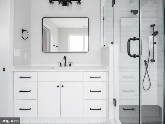 bathroom with vanity and a shower with door