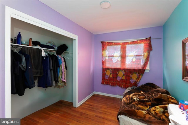 bedroom with a closet and dark hardwood / wood-style flooring