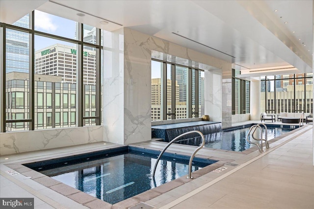 view of swimming pool featuring an indoor hot tub