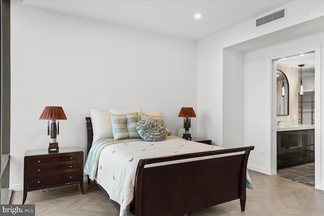 bedroom featuring connected bathroom and light parquet floors