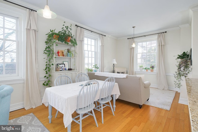 dining room featuring ornamental molding, plenty of natural light, and light hardwood / wood-style flooring