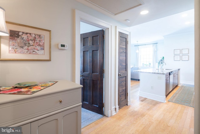 hall with light hardwood / wood-style flooring and sink