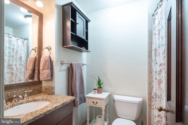 bathroom with vanity with extensive cabinet space and toilet