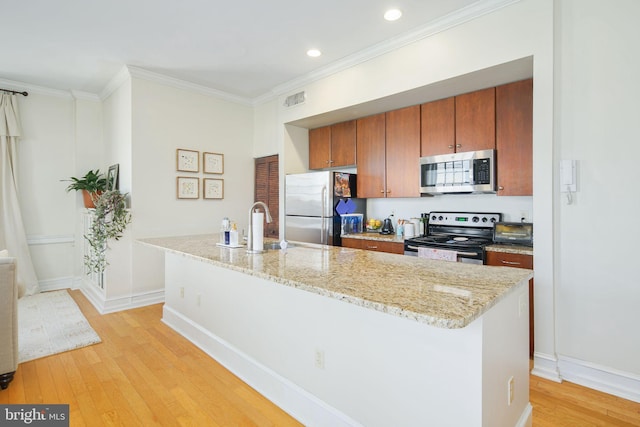 kitchen with appliances with stainless steel finishes, light stone counters, crown molding, light hardwood / wood-style flooring, and sink