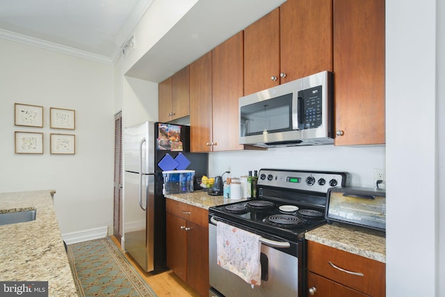 kitchen featuring appliances with stainless steel finishes, crown molding, light stone countertops, and light hardwood / wood-style floors