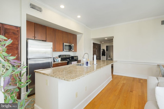 kitchen with appliances with stainless steel finishes, crown molding, sink, light wood-type flooring, and light stone counters