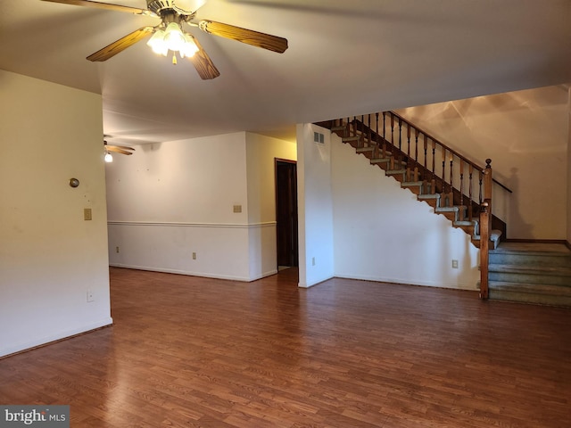 unfurnished living room featuring ceiling fan and dark wood-type flooring