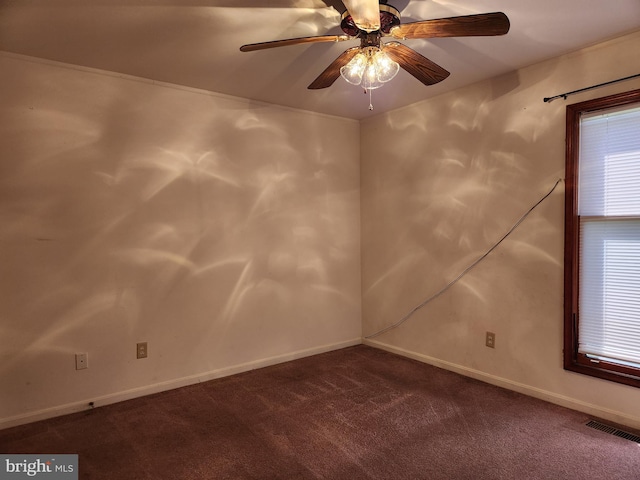 spare room with dark carpet and ceiling fan