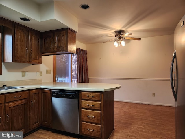 kitchen featuring kitchen peninsula, dark brown cabinets, stainless steel appliances, ceiling fan, and light hardwood / wood-style flooring