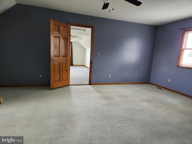 spare room with light carpet, ceiling fan, and vaulted ceiling