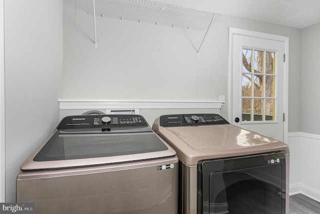 clothes washing area with dark hardwood / wood-style flooring and washing machine and dryer