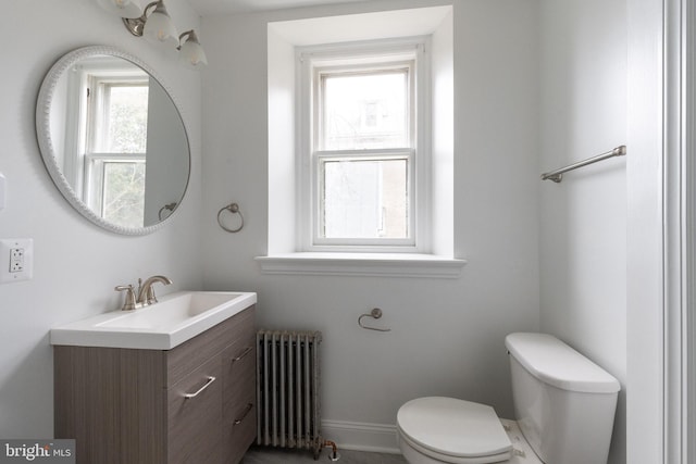 bathroom featuring oversized vanity, toilet, and radiator heating unit