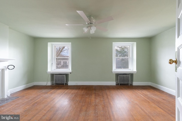 unfurnished room featuring ceiling fan, dark wood-type flooring, and radiator heating unit