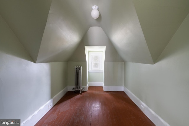 bonus room featuring dark wood-type flooring, vaulted ceiling, and radiator