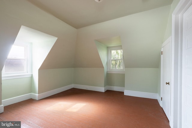 bonus room with lofted ceiling and dark hardwood / wood-style floors