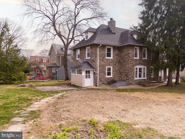 rear view of property with a playground