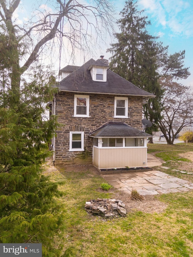 rear view of house featuring a lawn